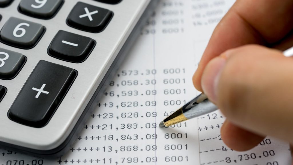 Person analyzing financial data on a laptop screen.